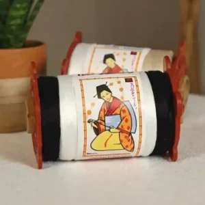 unas bobinas de hilo la japonesa junto a una planta en una mesa