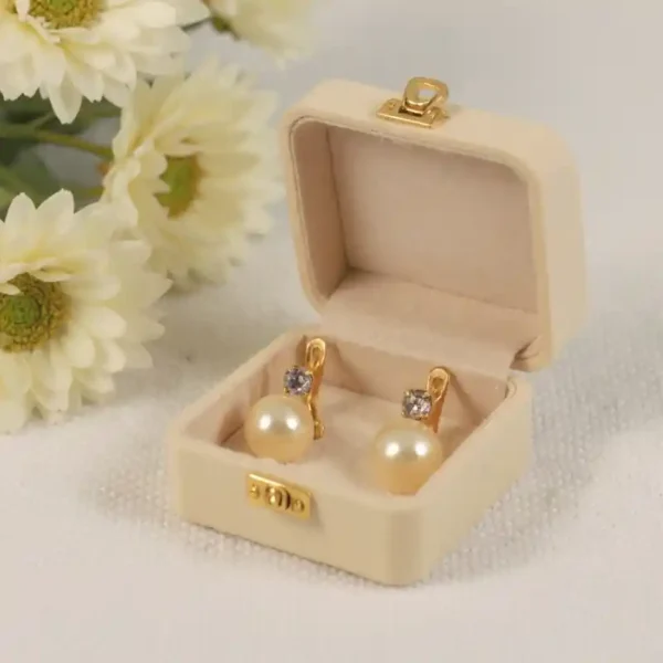 Pendientes de perlas sintéticas y circonitas en una cajas de terciopelo beige