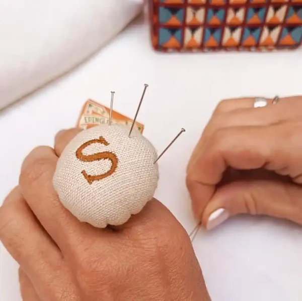 Manos de mujer usando en acerico petit atelier